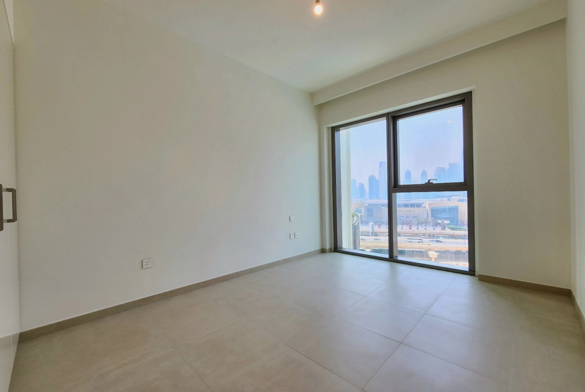 Exterior view of Downtown Views II, a modern apartment complex in Dubai, featuring sleek architectural design with glass facades, and an interior shot of a three-bedroom apartment with contemporary decor, large windows, and luxurious finishes.