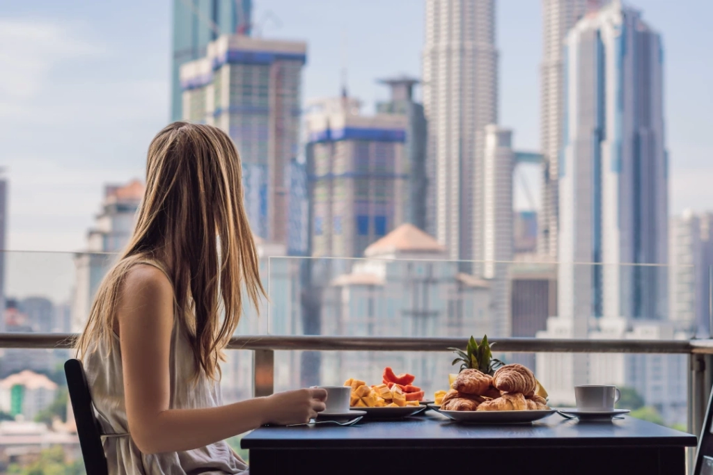 Image of a woman with breakfast: "Indulge in Dubai's hospitality amidst a sumptuous morning spread."
