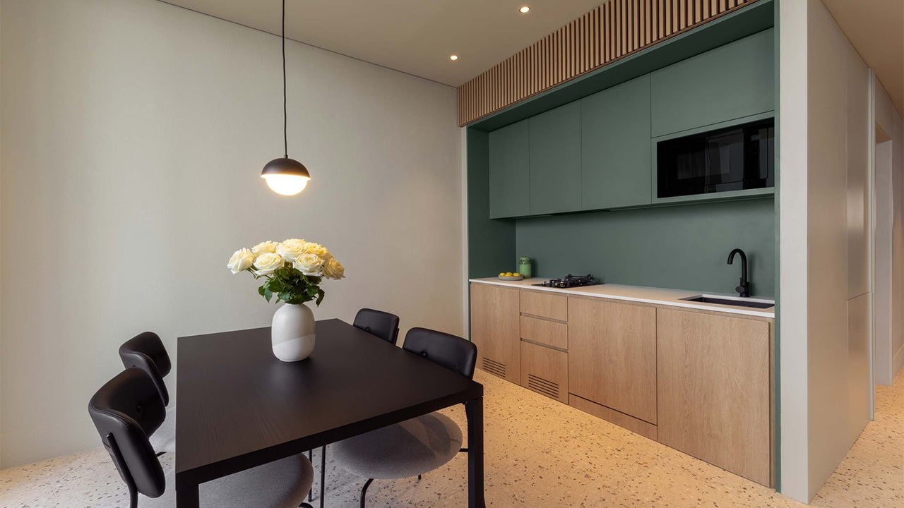 4-seat dining table and modern kitchen in the rental studio at Upside Living, Business Bay.