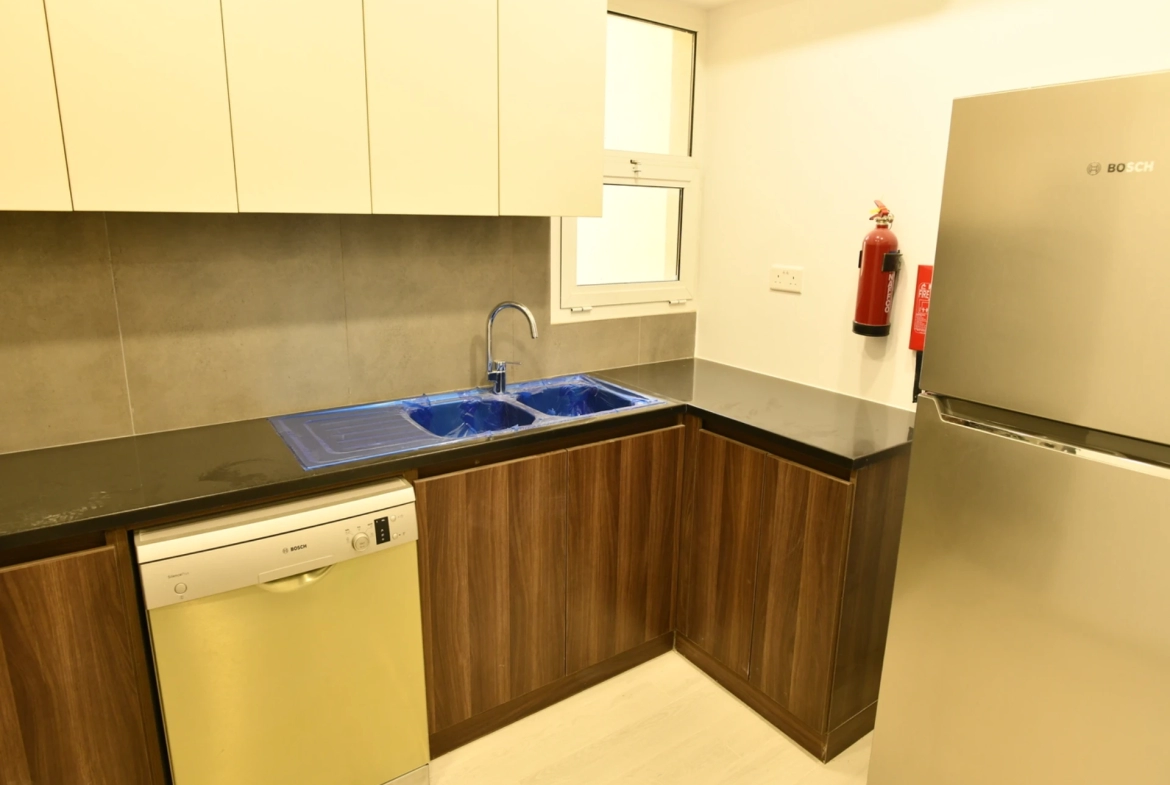 Furnished kitchen in a 2-bedroom apartment for sale in Al Rimth 13, Remraam, Dubai.