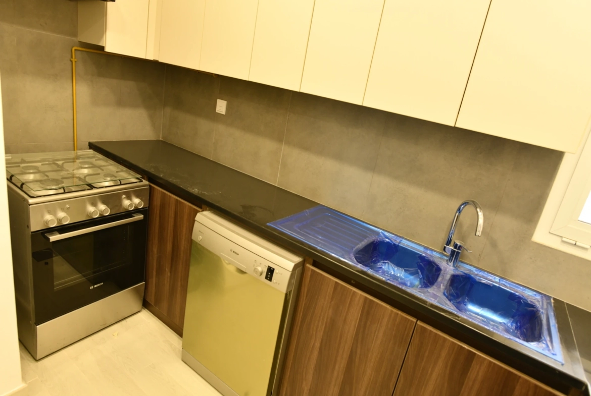 View of the furnished kitchen in a 2-bedroom apartment for sale in Al Rimth 13, Remraam, Dubai.