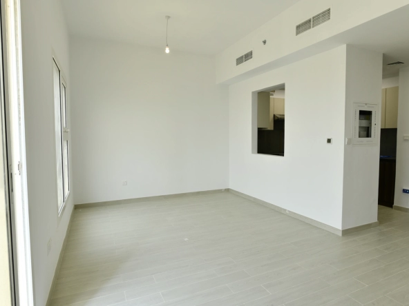 Semi-open kitchen connected to the living room in a 2-bedroom apartment for sale in Al Rimth 13, Remraam, Dubai.