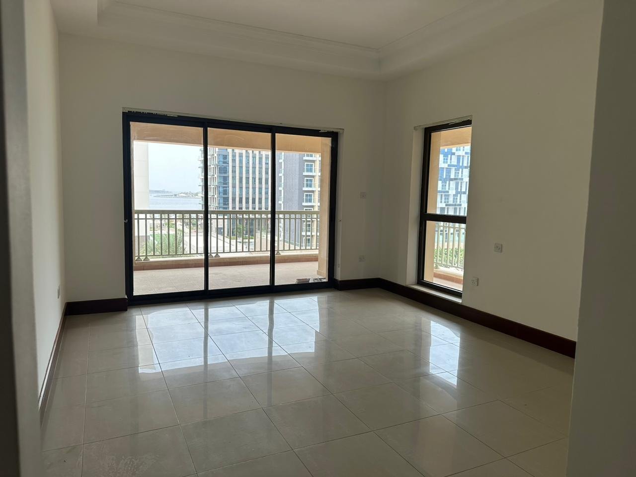 Living room with a view of the outside in a 2-bedroom apartment for rent in Golden Mile 5, Palm Jumeirah, Dubai.